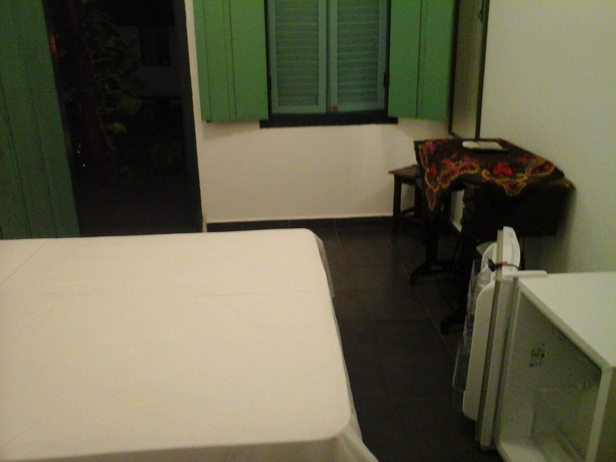 A room with a bed, a desk, and a chair.