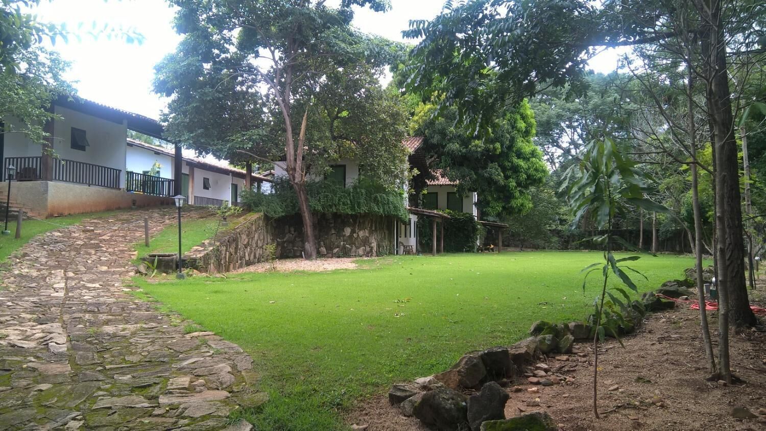 Un sendero de piedra que conduce a una zona ajardinada con un muro de piedra y un edificio con techo de tejas.