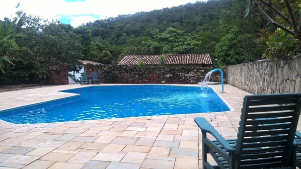 Una piscina al aire libre, sillones reclinables de piscina