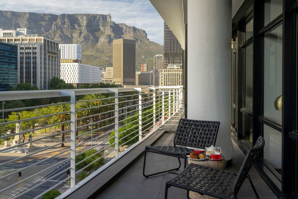 Un balcon offrant une vue sur la ville et les montagnes.