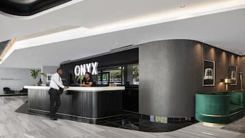 A modern reception desk with a black and white color scheme, a large sign reading "ONYX," and a green accent chair.