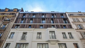Ein mehrstöckiges Gebäude mit moderner Fassade, großen Fenstern und Balkonen.