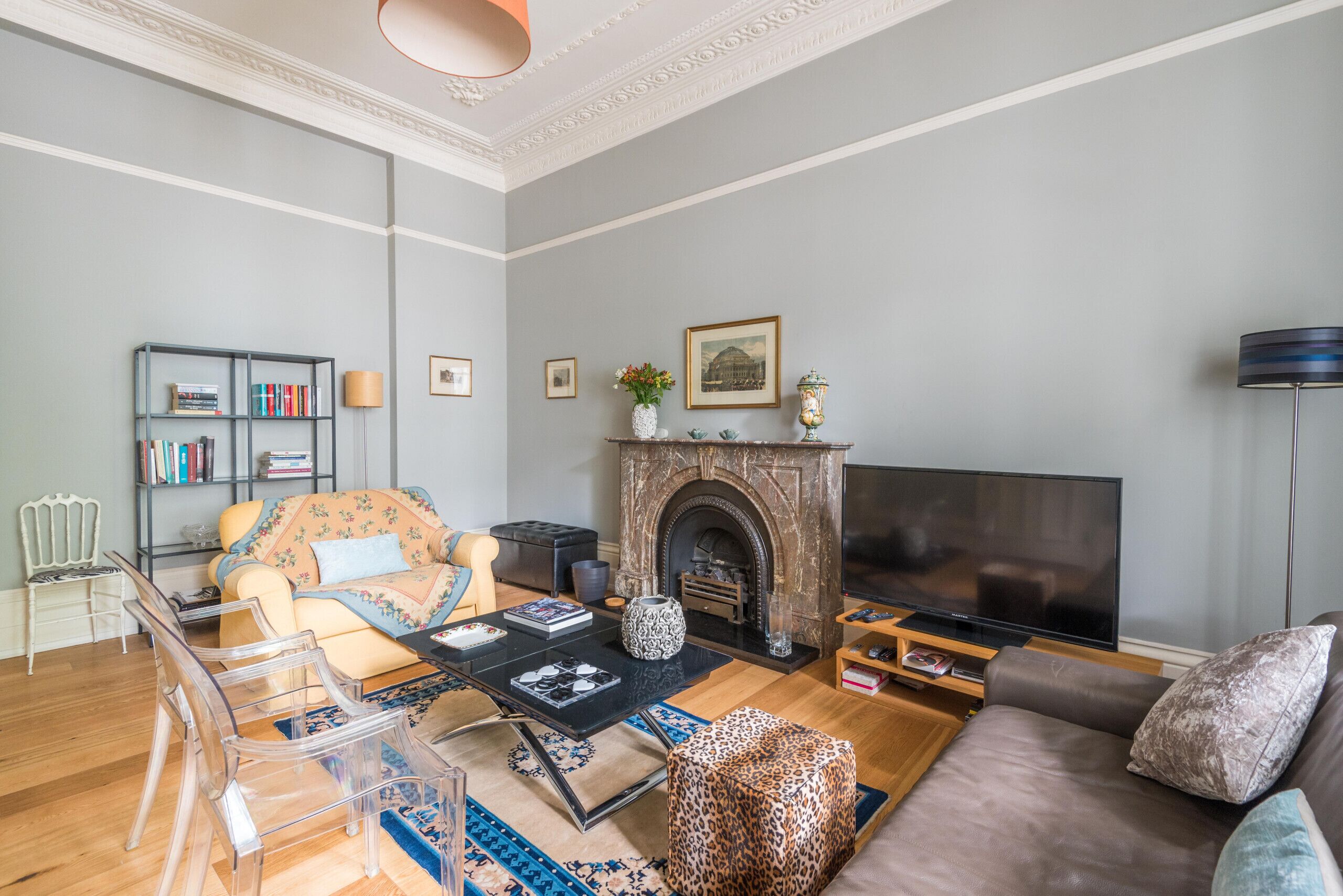 A living room with a fireplace, sofa, and TV.