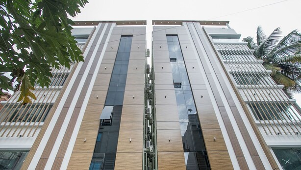 Een modern gebouw met een symmetrische gevel, met verticale houten panelen en grote ramen.
