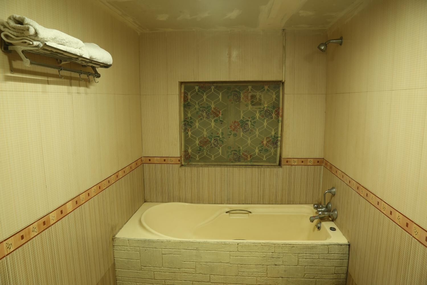 Un baño con bañera, perchero y ducha.