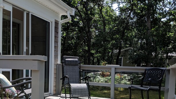 Une terrasse en bois aménagée avec du mobilier d’extérieur, notamment une chaise et un banc.