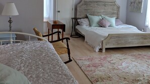 Une chambre avec deux lits, un bureau, une chaise et un tapis.