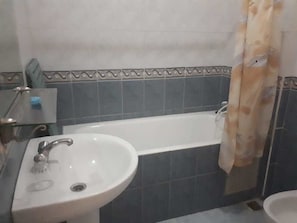 Tina profunda, regadera tipo lluvia, toallas 