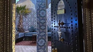 A traditional Moroccan door with intricate tile work and a brass door knocker. - Dar Dikrayat (Marrakech)