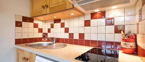 A compact kitchen with a sink, a dishwasher, and a microwave.