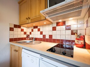 A compact kitchen with a sink, a dishwasher, and a microwave.