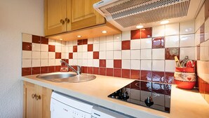 A compact kitchen with a sink, a dishwasher, and a microwave. - Renovated 3* studio in La Clusaz with south terrace (La Clusaz)