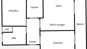 Un plan d’étage comprenant un salon, une cuisine, un coin repas, deux chambres, une salle de bain, un balcon et des toilettes séparées.