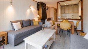 Una sala de estar acogedora con un sofá, una mesa de centro y un comedor con sillas.