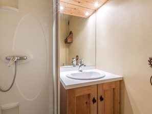 Une salle de bain avec une douche, un lavabo et un miroir.