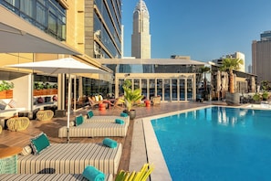 Una piscina al aire libre, sombrillas, tumbonas