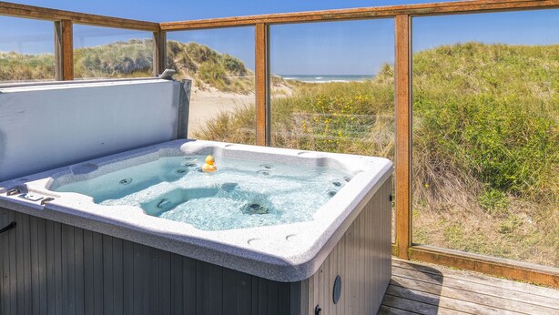Un jacuzzi con vista a la playa y las dunas.