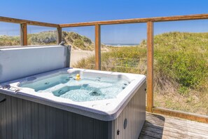Un bain à remous avec vue sur la plage et les dunes.