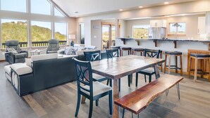 Un salón amplio con una gran mesa de comedor de madera, asientos cómodos y vistas al exterior.