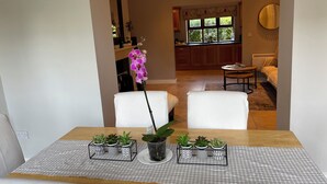 A dining area with a checkered tablecloth, white chairs, and potted plants. - Elegant  townhouse steps from historic Birr Castle Demense  (Birr)