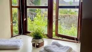 A room with a large window, a potted plant, and two towels on the windowsill. - Elegant  townhouse steps from historic Birr Castle Demense  (Birr)