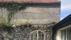 A stone building with a window, two chairs, and a small table. - Elegant  townhouse steps from historic Birr Castle Demense  (Birr)