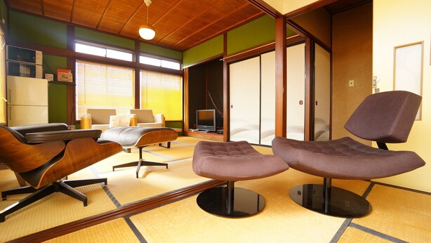 A traditional Japanese-style room with tatami flooring, a low table, and a television. - Super Tomato House Takayama (Takayama)