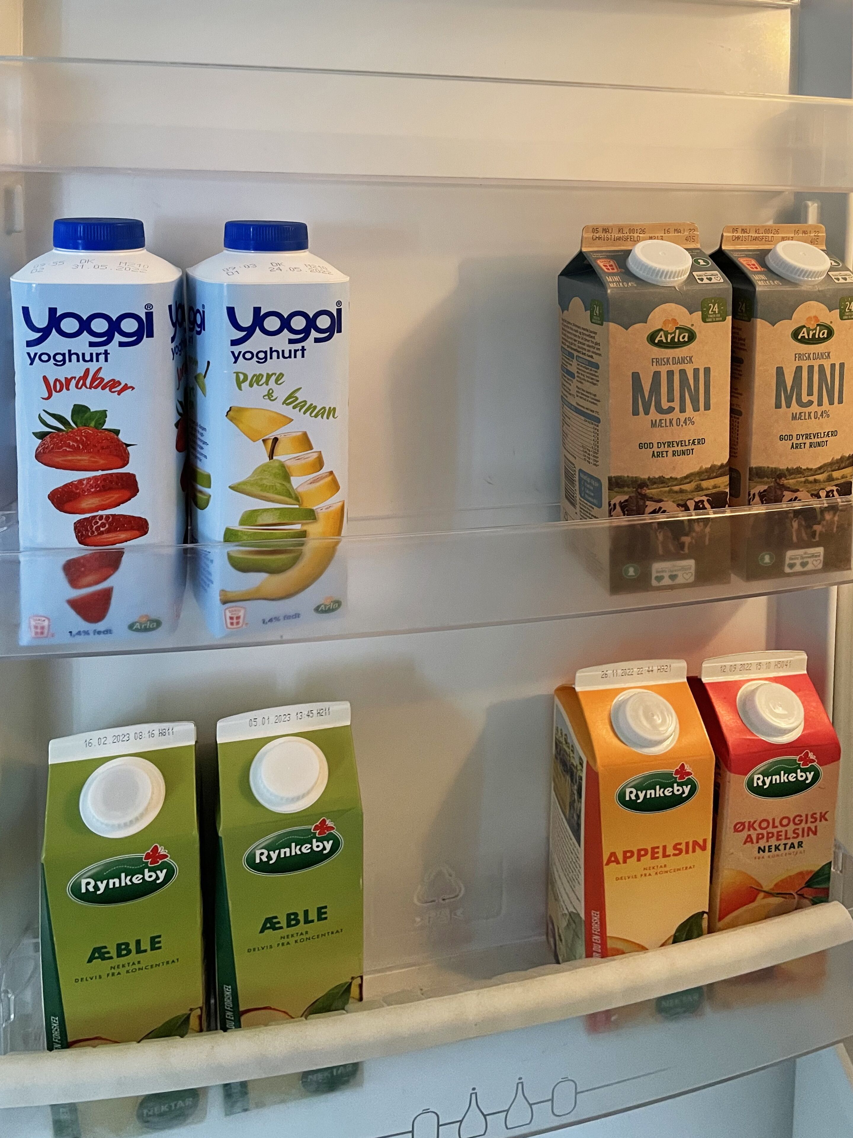 A refrigerator stocked with various dairy products including yogurts and juices.