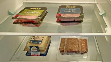 A refrigerator with two TÖLIP ham products and two packages of Riberhus bread.