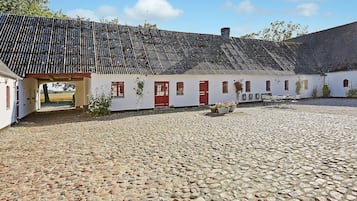 A traditional building with a tiled roof and a cobblestone courtyard.