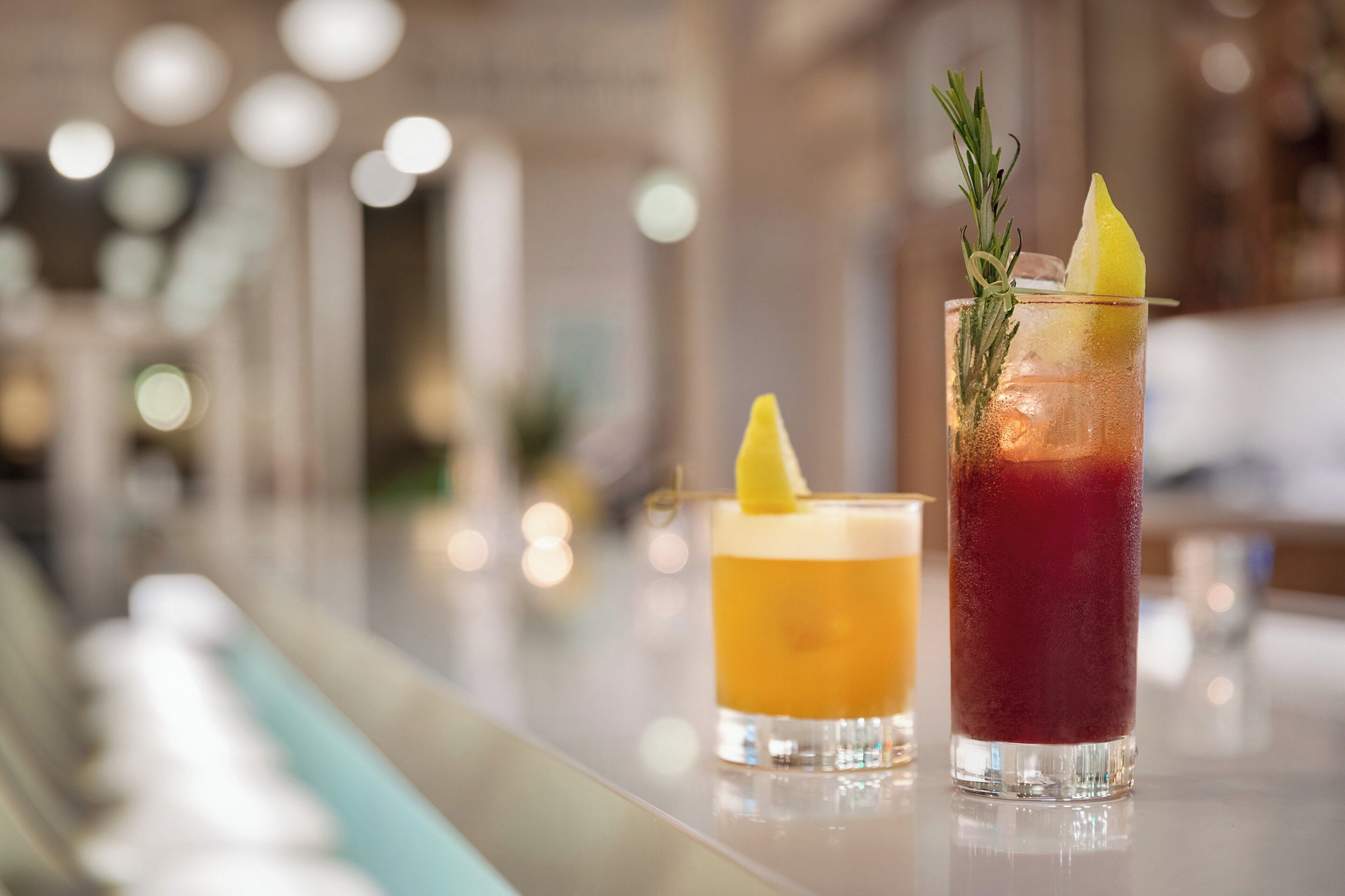 Two drinks on a bar counter with a blurred background.