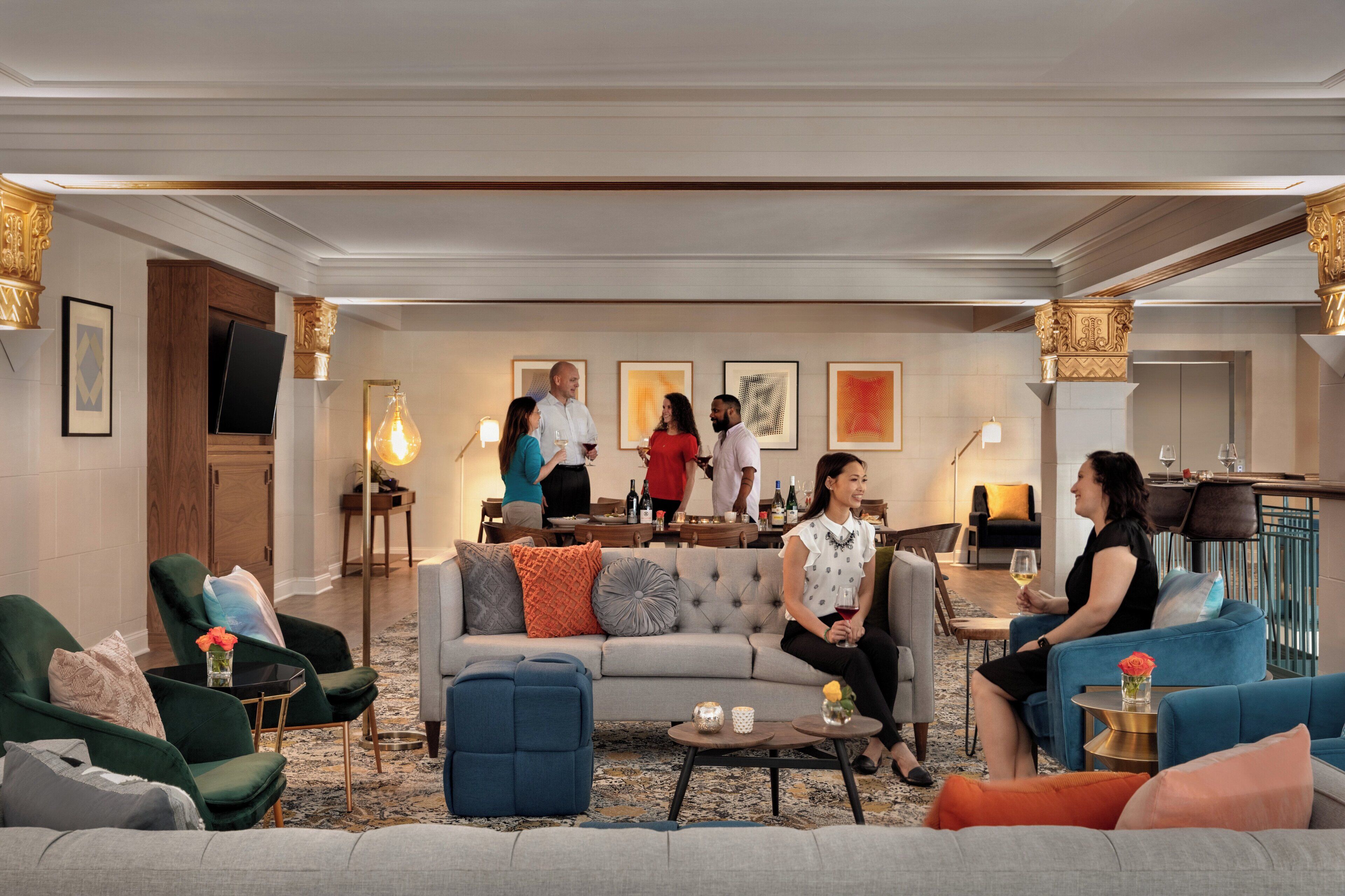 A spacious lounge area with multiple seating options, a central coffee table, and a bar area in the background.