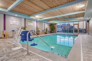 A pool area with a no diving sign, a lifeguard chair, and a view of the cityscape through large windows. - Home2 Suites by Hilton Indianapolis Northwest (Indianapolis)