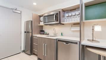 A compact kitchen with a microwave, refrigerator, and dishwasher.