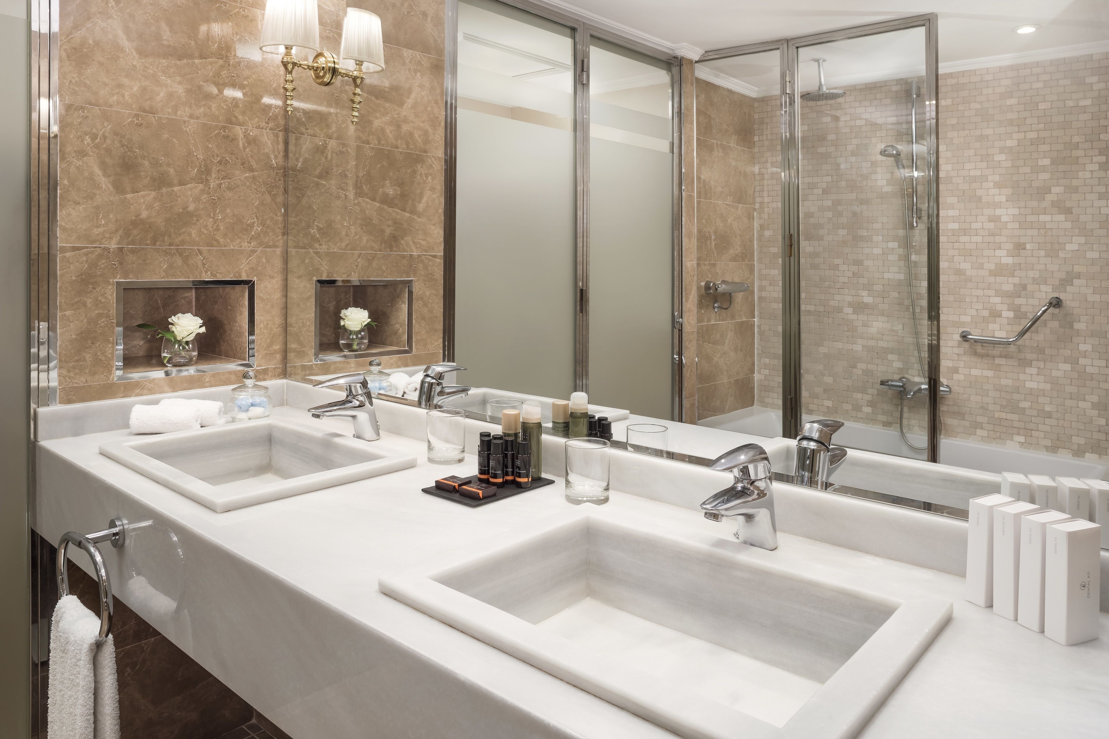 Un baño moderno con dos lavamanos, un espejo grande y una cabina de ducha de vidrio.