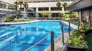 Una piscina al aire libre de temporada, sillones reclinables de piscina