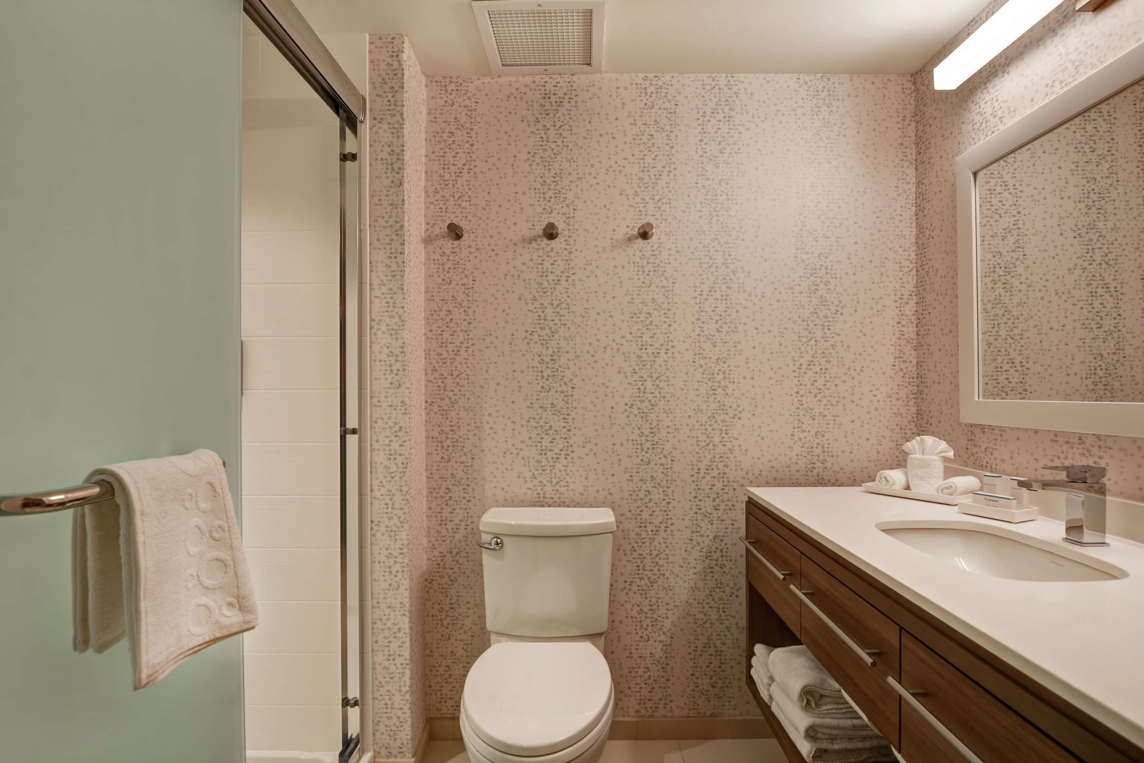 A bathroom with a toilet, sink, and shower.