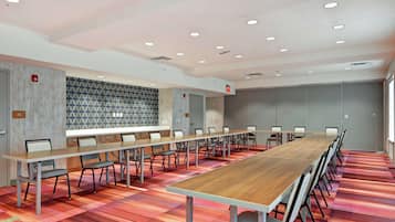 A conference room with a long table, chairs, and a patterned wall.