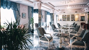 A luxurious lobby with ornate chandeliers, striped upholstered chairs, and a marble floor. - Emerald Suite Hotel (Baku)