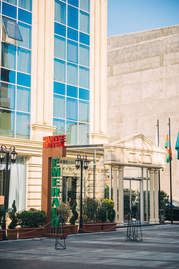 Fachada de hotel con un letrero grande, diseño de vidrio y estilo arquitectónico clásico.