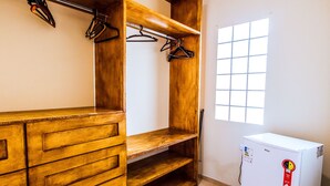 A room with wooden shelving, a white refrigerator, and a window with a grid pattern. - VELINN Pousada Praia do Perequê (Ilhabela)