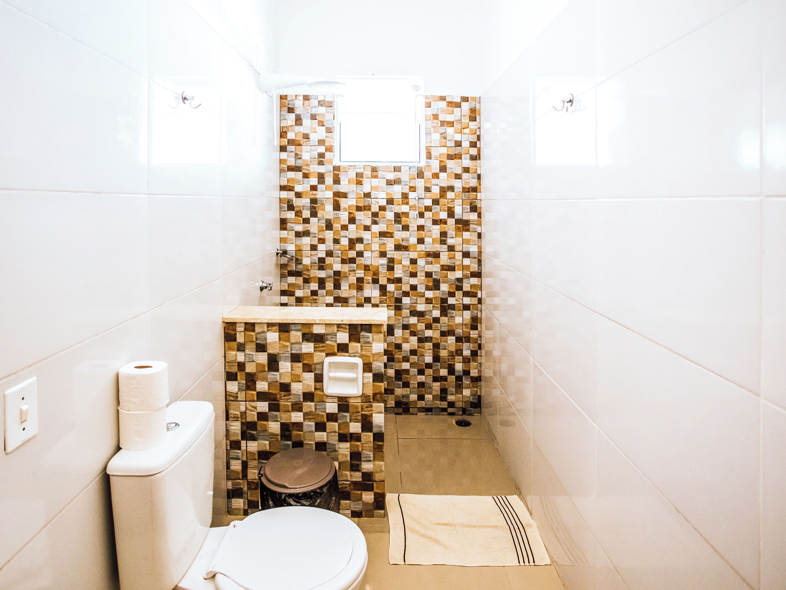 A small bathroom with a toilet, a sink, and a shower area.
