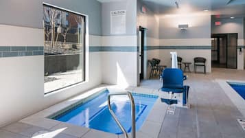 A pool area with a safety sign, a window with a view, and seating by the pool.