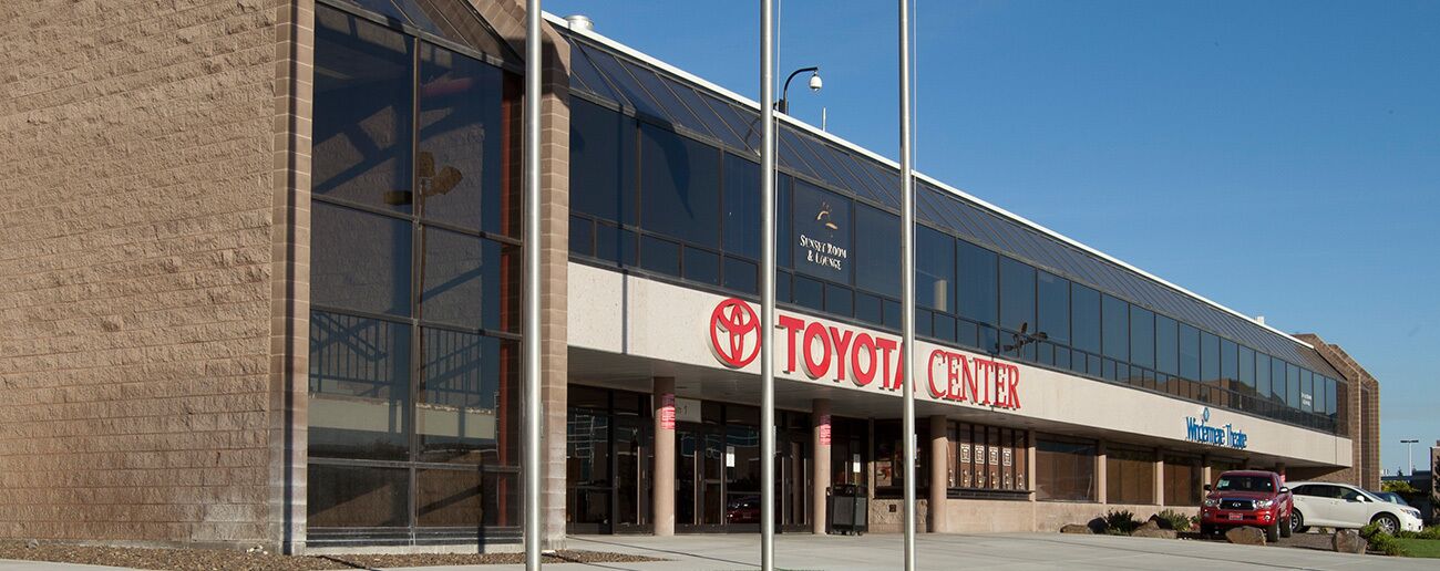 A Toyota Center with a large glass facade and a brick exterior.