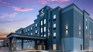 A modern hotel with a flat roof, multiple windows, and a prominent entrance.