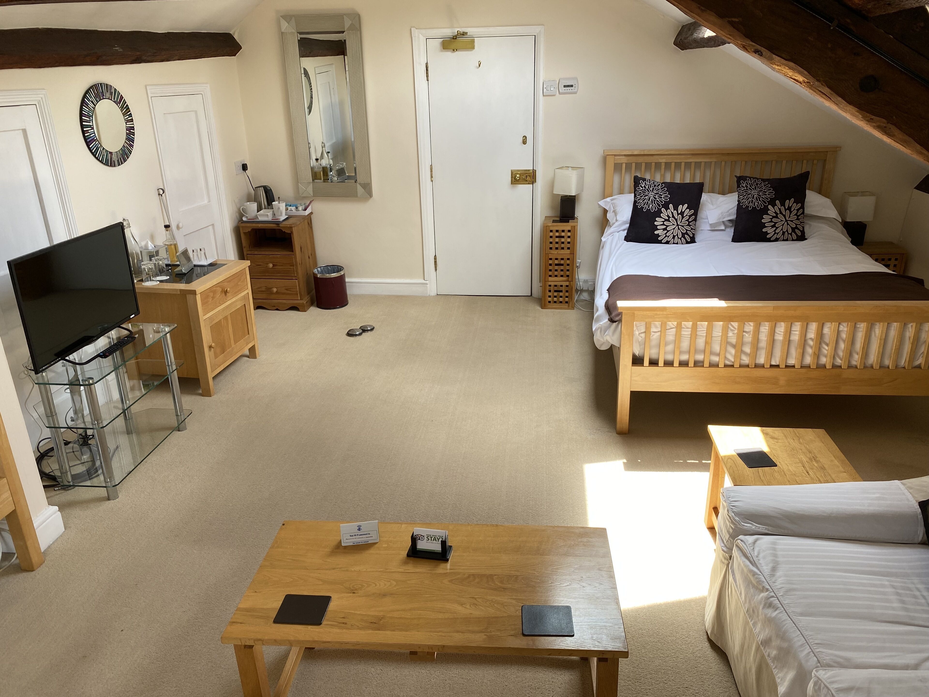 A bedroom with a bed, bedside tables, a TV, and a desk with a computer.