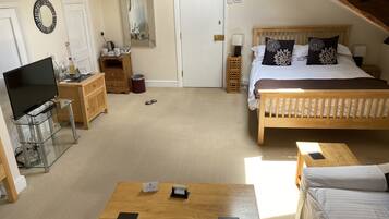 A bedroom with a bed, bedside tables, a TV, and a desk with a computer.