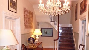 A traditional interior with a chandelier, a staircase, and a dining area with chairs and a table. - Town Mills B &B (Dulverton)