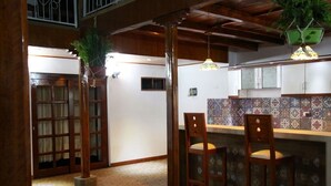 A traditional Japanese-style interior with tatami flooring, wooden pillars, and a low ceiling. There are two wooden chairs and a small table in the center. - Casa Kuelap Hostal (Chachapoyas)