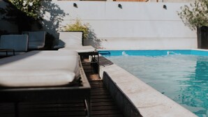 A poolside area with lounge chairs and a wooden deck. - Premium Tower Suites (Mendoza)